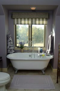 A bathroom with purple walls and a bathtub.