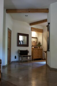 A hallway with wooden beams and a bench.