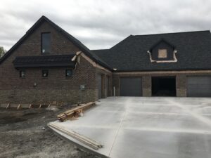 A house under construction with a garage and driveway.