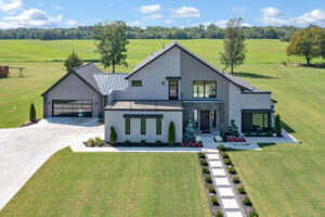 An aerial view of a modern home in a field.