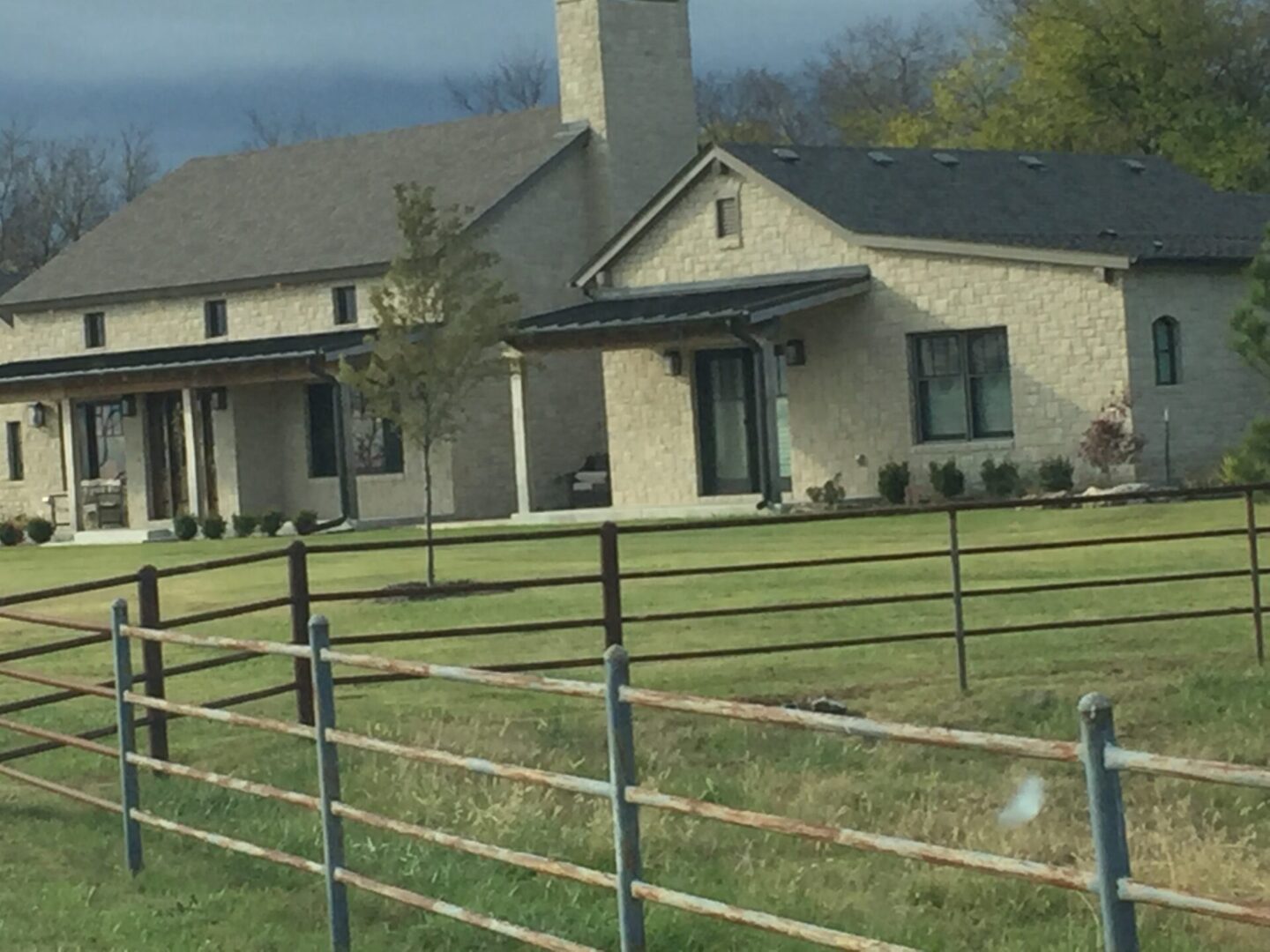 A house with a fence in the middle of a field.