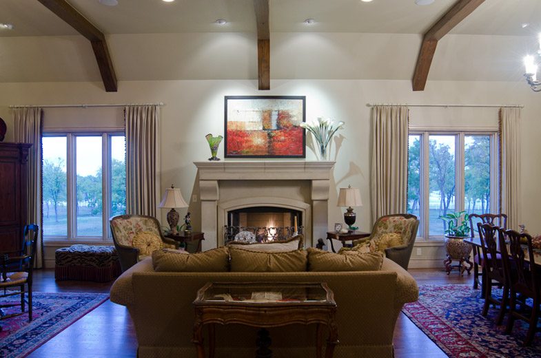 A living room with a fireplace and a dining table.