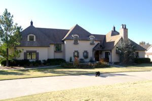 A large house with a dog in front of it.