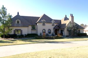 A tan house with a driveway.