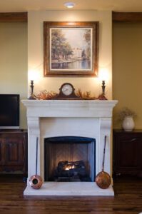 A living room with a fireplace and a painting on the wall.