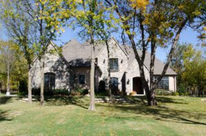 A large stone house in the middle of a grassy yard.