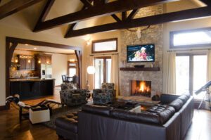 A living room with wood beams and a fireplace.