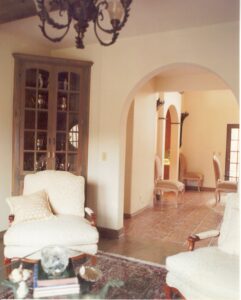 A living room with chairs and a chandelier.