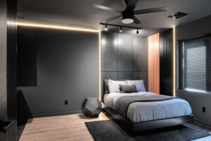 A bedroom with a bed and a ceiling fan.