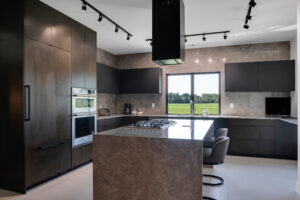 A modern kitchen with black cabinets and counter tops.