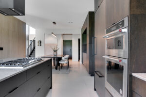 A modern kitchen with black cabinets and stainless steel appliances.