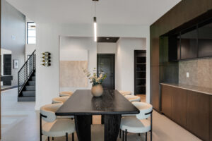 A modern dining room with a black table and chairs.