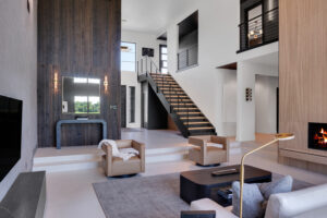 A modern living room with a fireplace and stairs.