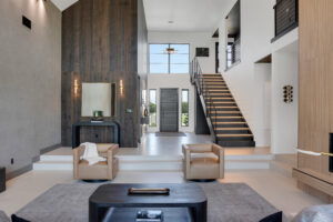 A modern living room with wooden walls and a staircase.