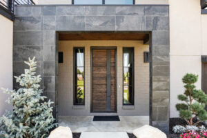 A modern home with a wooden door and landscaping.