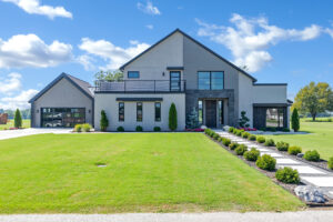 A modern home with a driveway and grass.